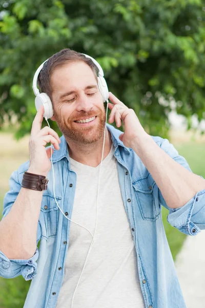 Casual guy listening music outdoors