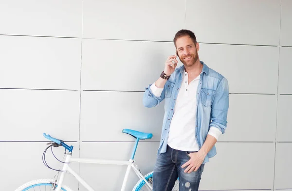 Ragazzo accanto alla bicicletta con il telefono cellulare — Foto Stock