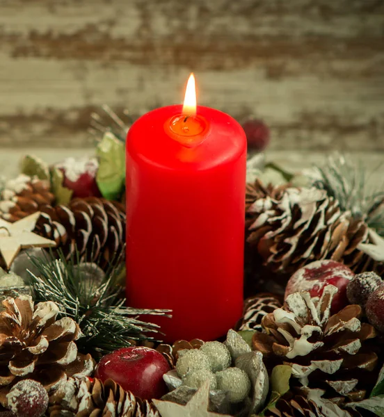 Red candle lit and pine cones Stock Photo