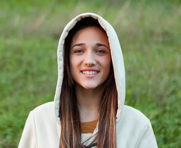 Lachende tiener meisje buiten met kap — Stockfoto