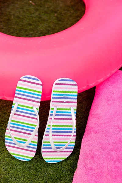 Pink lifebuoy colorful flip-flops and ball — Stock Photo, Image