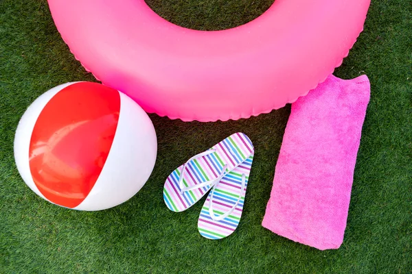 Pink lifebuoy colorful flip-flops and ball — Stock Photo, Image