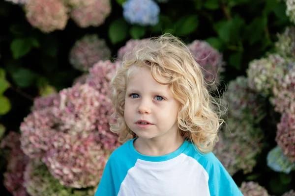 Niño con el pelo rubio en el jardín —  Fotos de Stock
