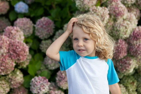 Niño con el pelo rubio en el jardín — Foto de Stock