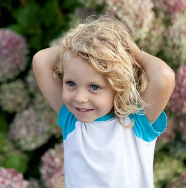 Kind met blond haar in de tuin — Stockfoto