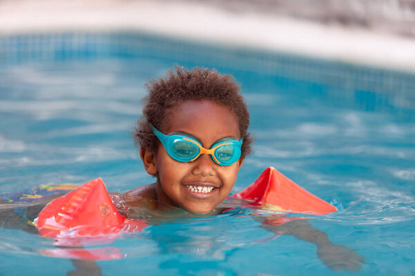 kid with sleeve floats swimming in pool 