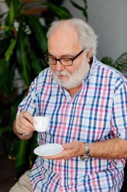 Büyük adam kahve içiyor. 