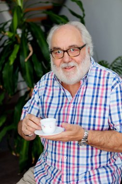 Büyük adam kahve içiyor. 