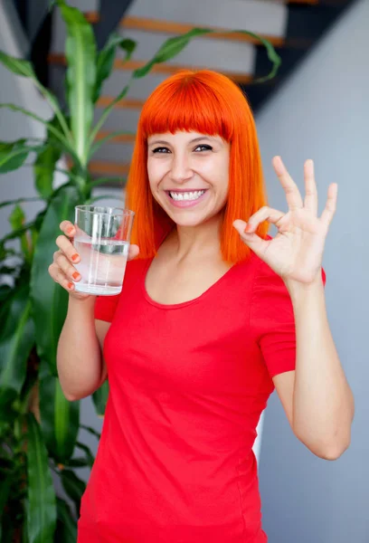 Рыжая женщина пьет воду — стоковое фото