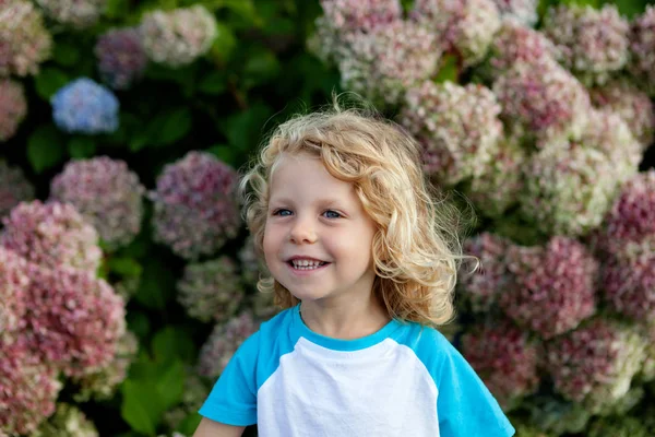 Bambino con capelli biondi in giardino — Foto Stock