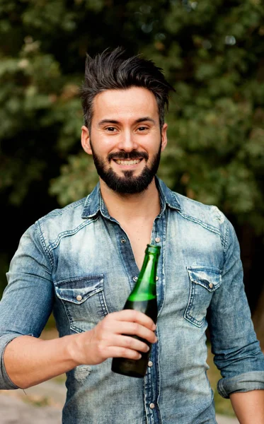 Junger bärtiger Mann trinkt Bier — Stockfoto