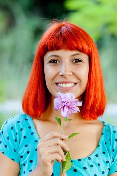 Rødhåret ung kvinde med blomst - Stock-foto