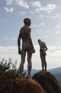 Heykel: Unutulan iç savaş ve diktatörlük. El Torno bakış. Caceres, İspanya. Günbatımı bulutlu gökyüzü karşı heykeller