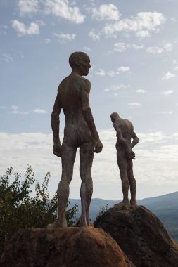 Sculptures: The forgotten civil war and dictatorship. Viewpoint of El Torno. Caceres, Spain. Statues against sunset cloudy sky clipart