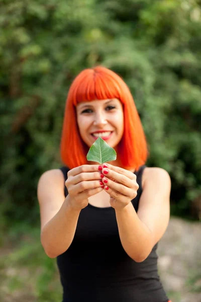 Beautiful woman holding green leaf — Stock Photo, Image