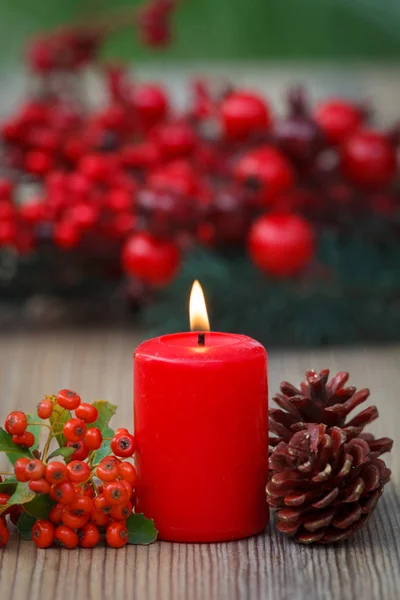 Vela roja ardiente y conos de pino —  Fotos de Stock