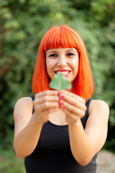 Όμορφη γυναίκα εκμετάλλευση πράσινο φύλλο — Φωτογραφία Αρχείου