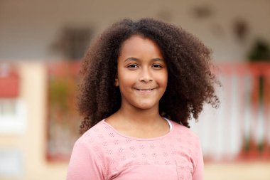 Sokağın ortasında gülümseyen sevimli Afro-Amerikan kız