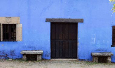 Mavi dış cephe eski evin pencereleri ve ahşap kapı, Cceres, İspanya