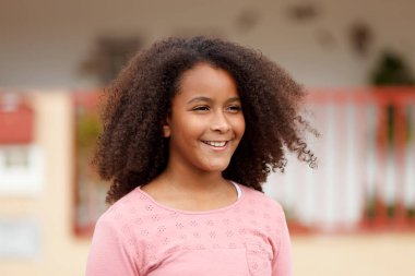 Sokağın ortasında gülümseyen sevimli Afro-Amerikan kız