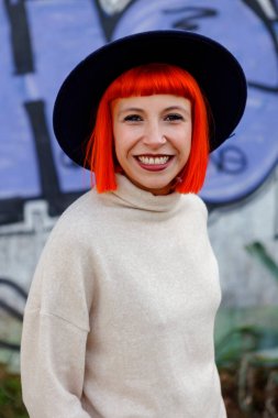 boyalı duvarın üzerinden şapkalı çekici kadın