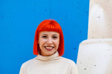 çekici kırmızı saçlı genç kadın mavi arka plan üzerinde