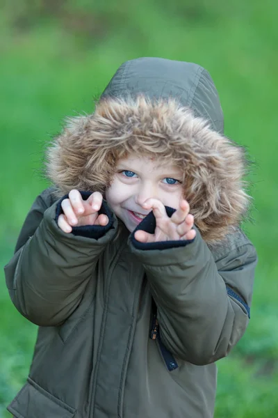 幸せな小さな子のコートを着て 手を屋外に表示中の肖像画 — ストック写真