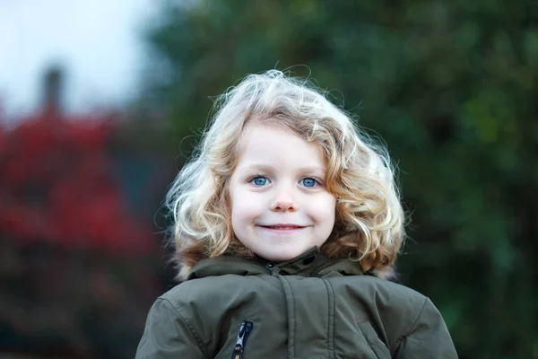 屋外コートで長いブロンドの髪を持つ幸せな小さな子の肖像画 — ストック写真