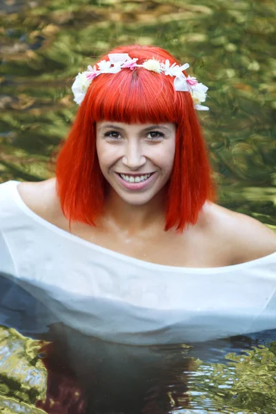 白いドレスと川で入浴の花輪を身に着けている美しい若い女性 — ストック写真
