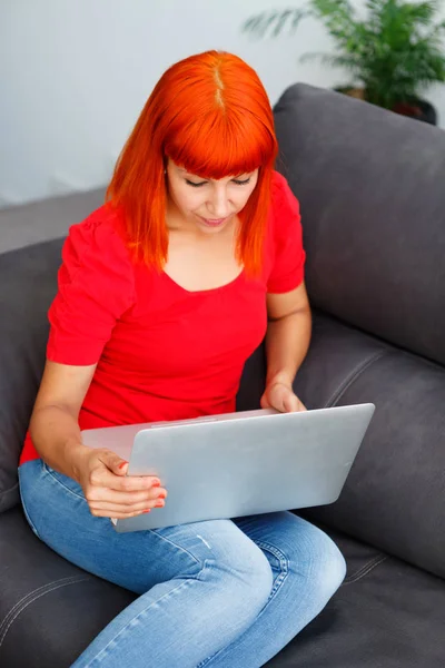 Rude Szczęśliwą Kobietą Czerwone Ubrania Pomocą Laptopa Domu — Zdjęcie stockowe