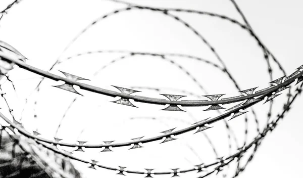 fence with barbed wire and sky, closeup