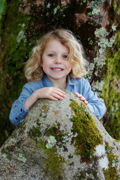Счастливый Маленький Мальчик Длинными Светлыми Волосами Позирует Деревом — стоковое фото