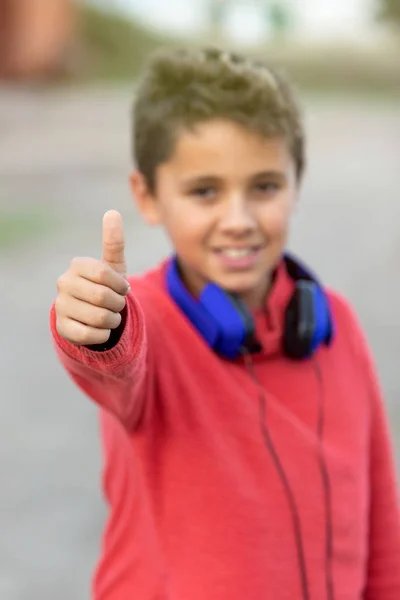 Kind mit dunklen Haaren hört Musik mit blauen Kopfhörern — Stockfoto