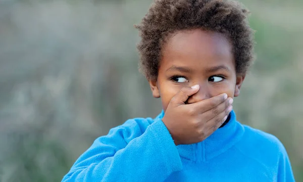 Liten afrikansk pojke som täcker hans mun — Stockfoto