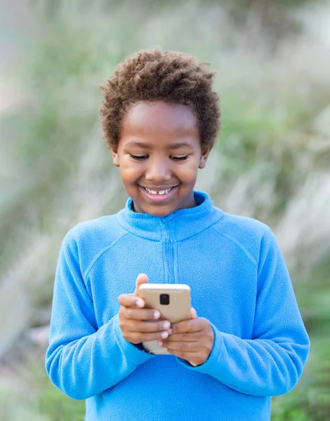 Adorable niño africano con un teléfono móvil — Foto de Stock