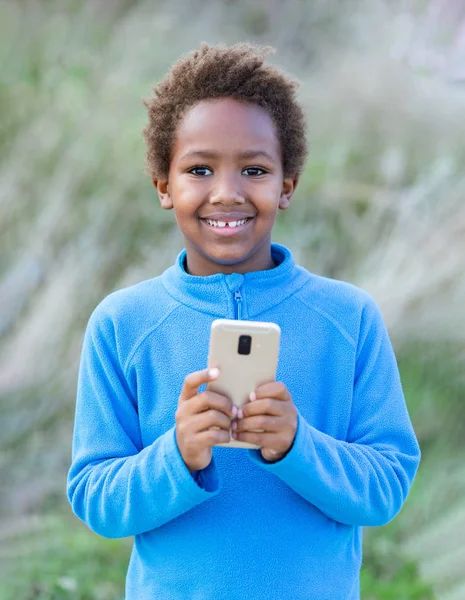 Criança africana adorável com um telefone móvel — Fotografia de Stock