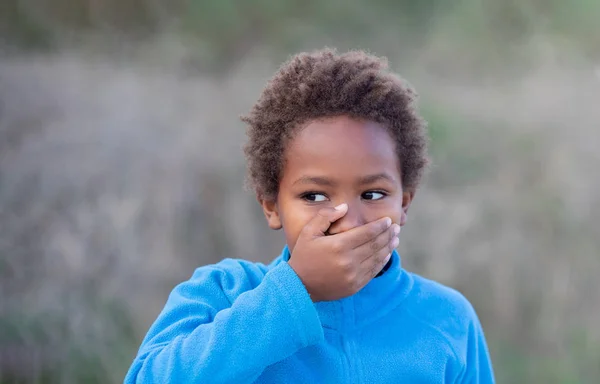Pequeño chico africano cubriéndose la boca Fotos de stock libres de derechos