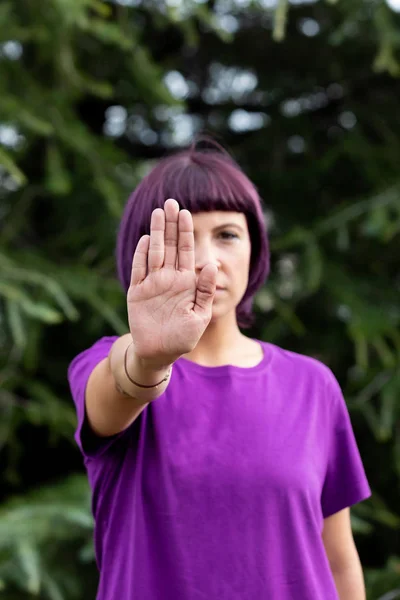Angry woman with in purple showing the hand palm saying STOP — Stock Photo, Image