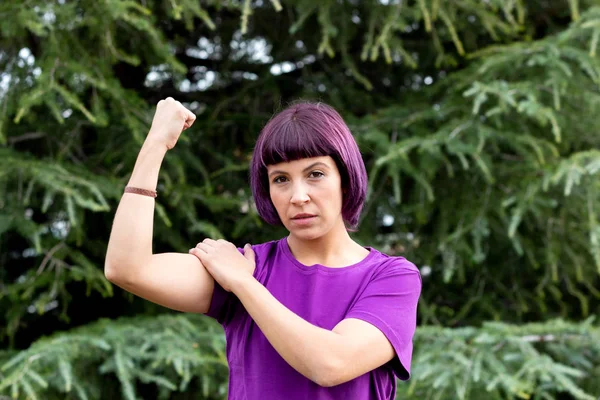 Mujer en púrpura mostrando su bíceps — Foto de Stock