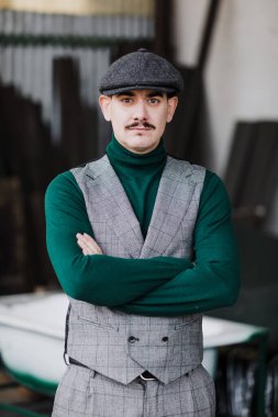 Gri retro takım elbiseli, kep ve yeşil formalı iyi giyimli bir adam.