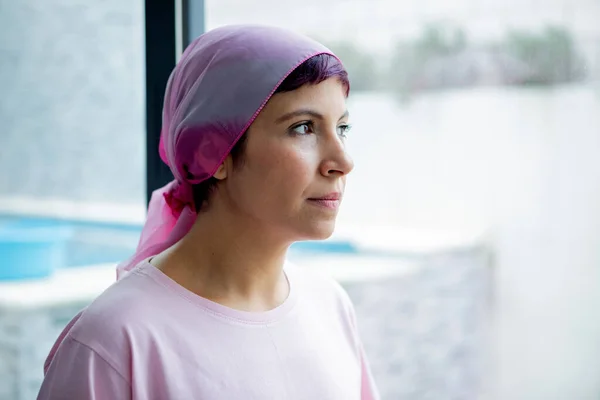 Woman with pink scarf on the head. Cancer awareness