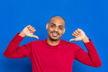 Mavi arka planda kırmızı formalı Afrikalı adam.