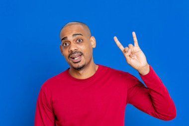 Mavi arka planda kırmızı formalı Afrikalı adam.