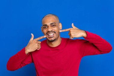 Mavi arka planda kırmızı formalı Afrikalı adam.