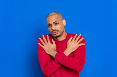 Mavi arka planda kırmızı formalı Afrikalı adam.