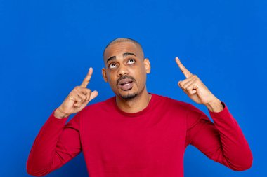 Mavi arka planda kırmızı formalı Afrikalı adam.