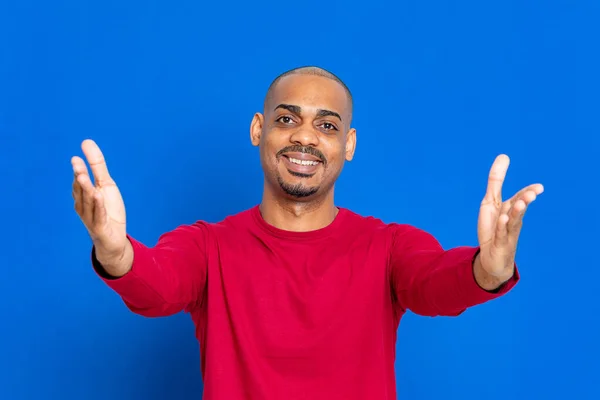 青い背景に赤いTシャツを着たアフリカ人男性 — ストック写真