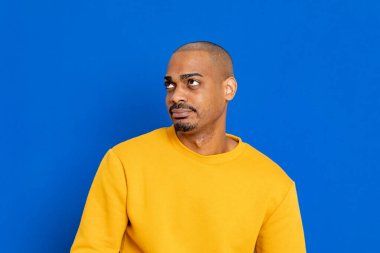 Mavi arka planda sarı formalı Afrikalı adam.