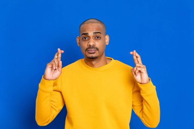 Mavi arka planda sarı formalı Afrikalı adam.