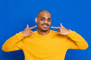 Mavi arka planda sarı formalı Afrikalı adam.